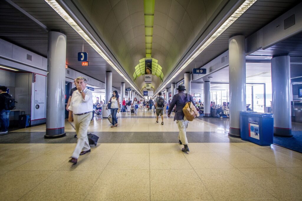 Business travelers walking through a long, bright O'Hare airport concourse