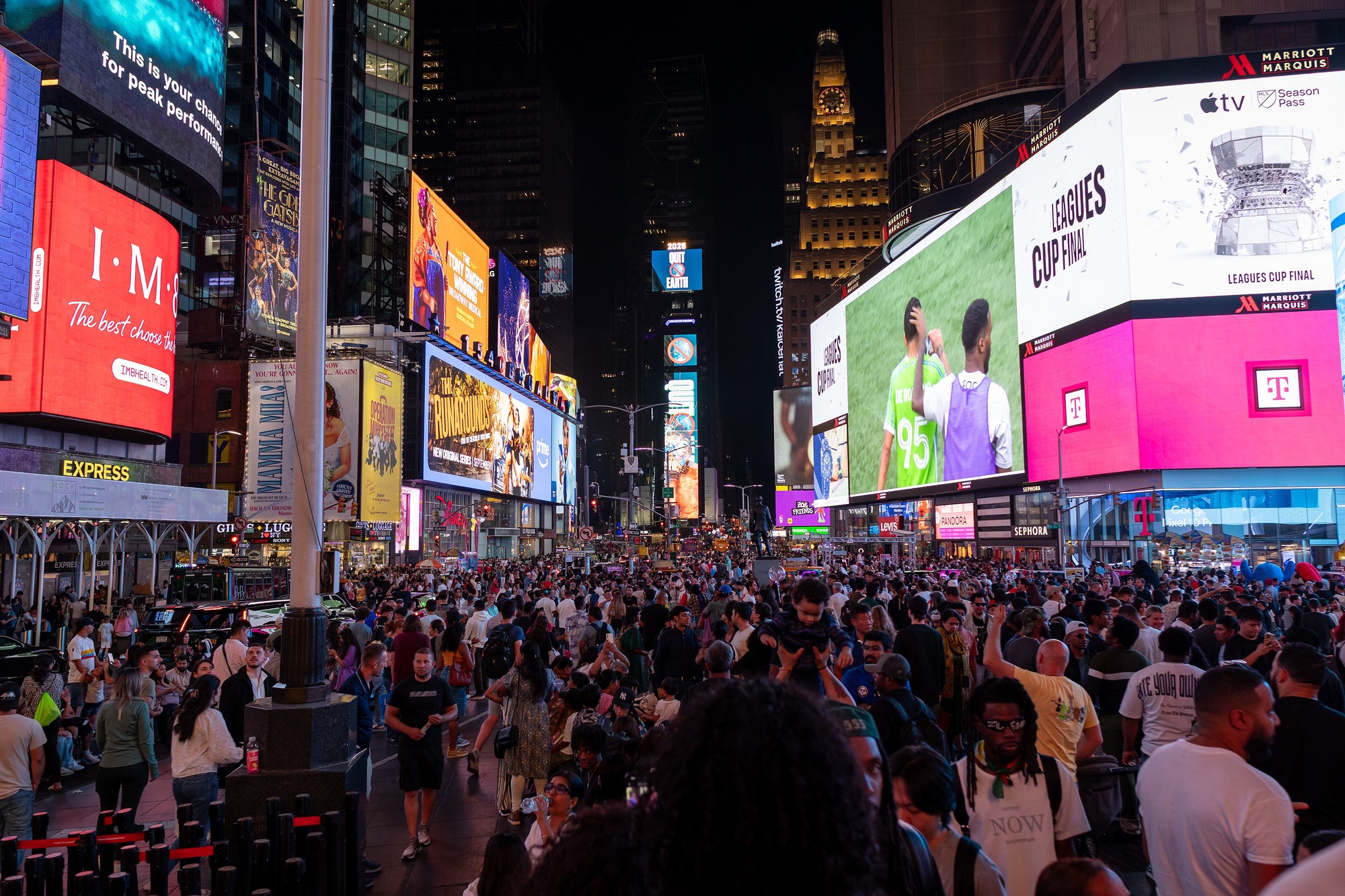Crowds and bright billboards in Times Square at night, August 2025