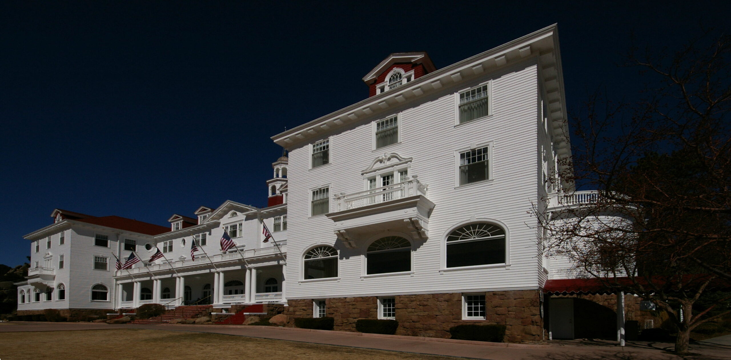 The main building of the Stanley Hotel in Estes Park, Colorado, a white Colonial Revival hotel against a blue sky